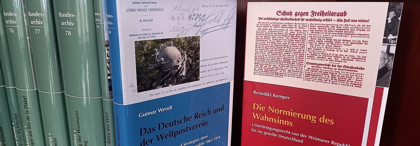 Verschiedene Publikationen des Bundesarchivs in Buchform mit grünen, blauen und roten Einbänden